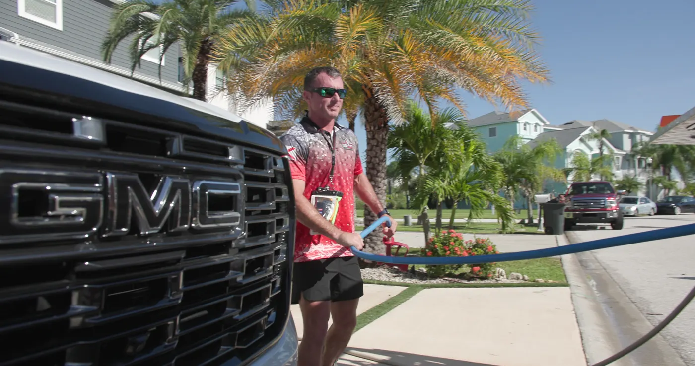 Iron Shield technician connecting the cleaning hose at the truck before starting a deck cleaning